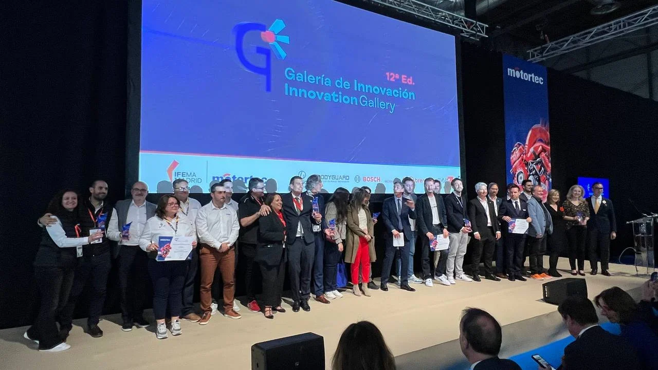 Un grupo de personas se encuentra en el escenario en el evento de la Galería de Innovación, sosteniendo certificados y posando para una foto.