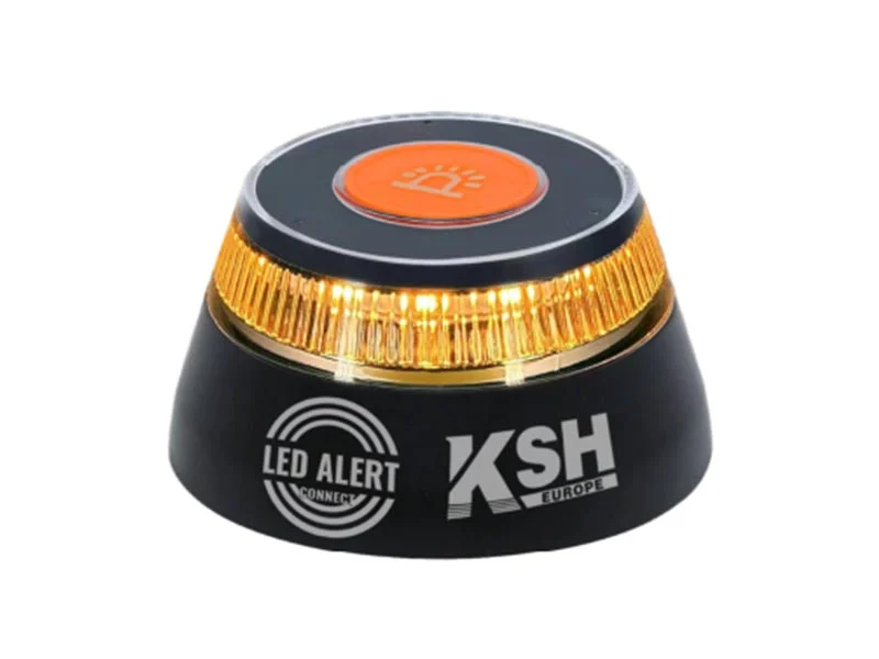 Dispositivo de alerta LED negro y naranja con luces amarillas intermitentes, logotipos "KSH" y "LED Alert Connect", ideal como baliza geolocalizada V16 para una mayor seguridad en la carretera.