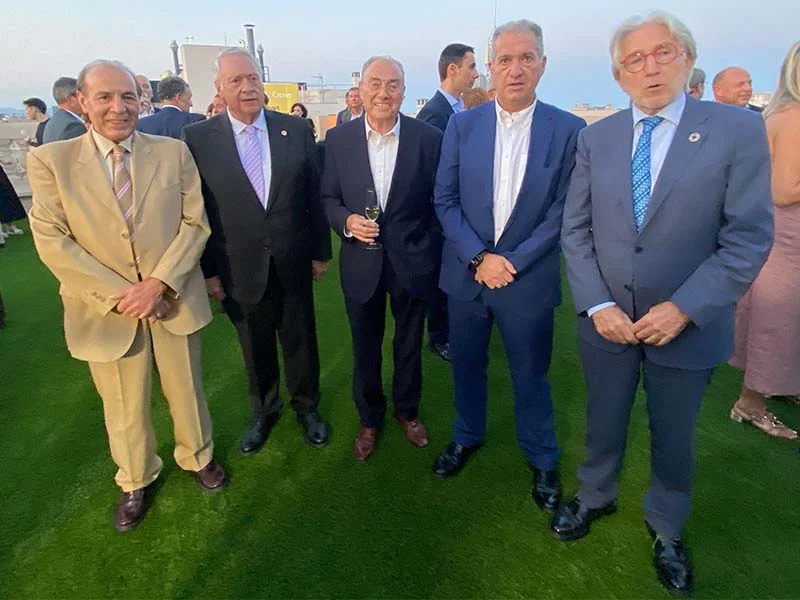 Cinco hombres trajeados posan sobre el césped de la Jornada del Metall 2025 para una foto de grupo en este evento al aire libre de UPM Metall.