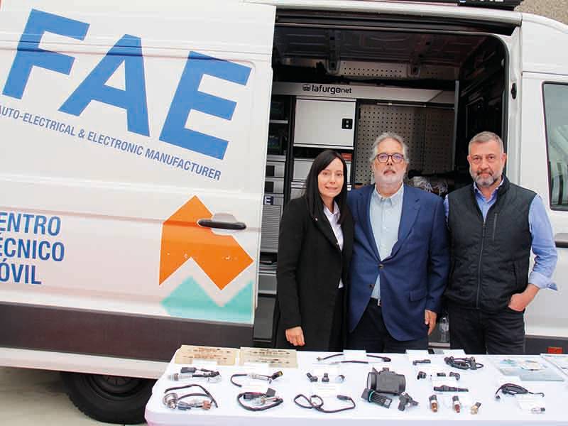 Tres personas junto a una furgoneta tecnológica móvil con equipos electrónicos expuestos en una mesa frente a ellas, marcando un paso de gigante en soluciones tecnológicas portátiles.