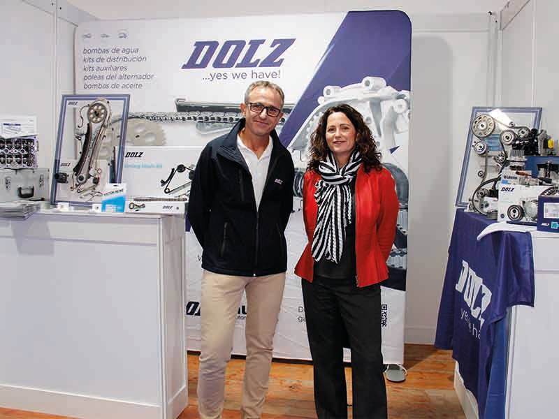 Dos personas frente a un expositor de Dolz en el que se exhiben piezas de automóvil y material promocional, lo que supone un paso de gigante para la marca.