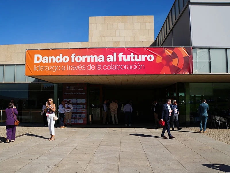 Un grupo de personas junto a un edificio con una pancarta en la que se lee "Dando forma al futuro" en español.