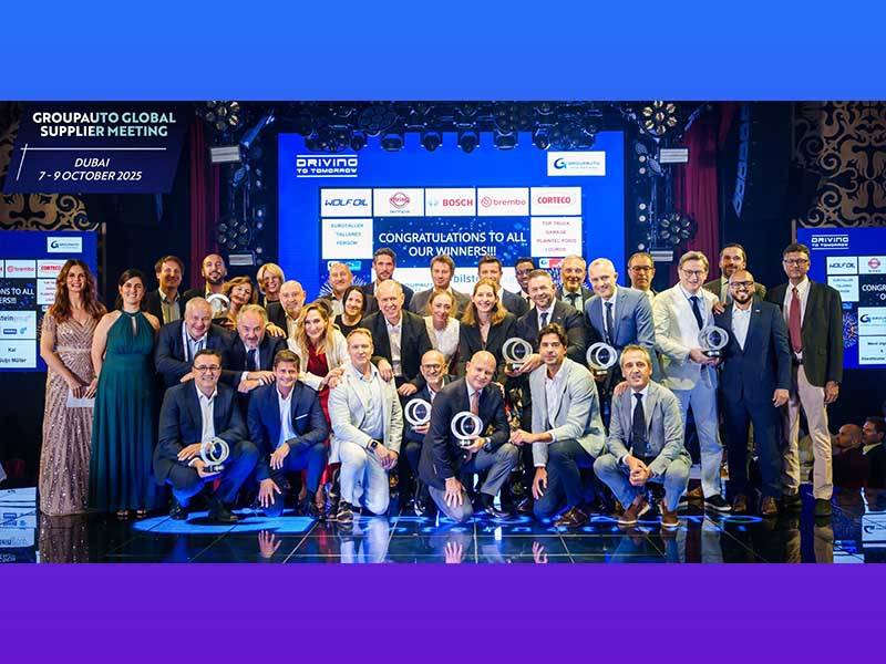 Un nutrido grupo de personas vestidas de etiqueta posan en el escenario con los premios en el evento 2025 GROUPAUTO Supplier Global Meeting en Dubai.