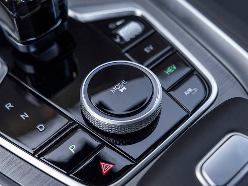 Detalle de la consola central del Ebro S700, con un mando selector de modos y varios botones para las funciones de conducción, destacando su lujoso diseño PHEV.