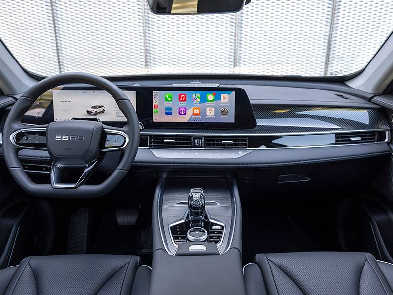 Moderno interior de coche con salpicadero digital, pantalla táctil central y elegante diseño en negro y plata, que ofrece la sensación de lujo de un Ebro S700 PHEV.