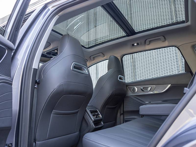 Experimenta el lujo del interior del Ebro S700 PHEV, con asientos traseros de cuero negro y un impresionante techo solar panorámico.