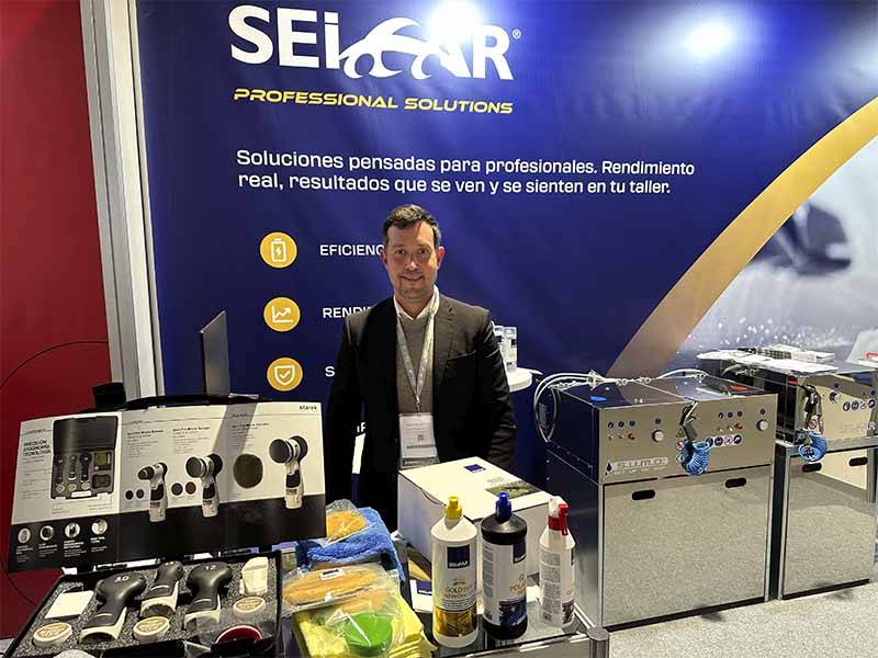 Un hombre junto a un stand de SEICAR en el que se exponen productos y equipos de limpieza en una feria comercial, destacando el éxito de asistencia y las soluciones innovadoras de cara a Balance de Equipia 2026.