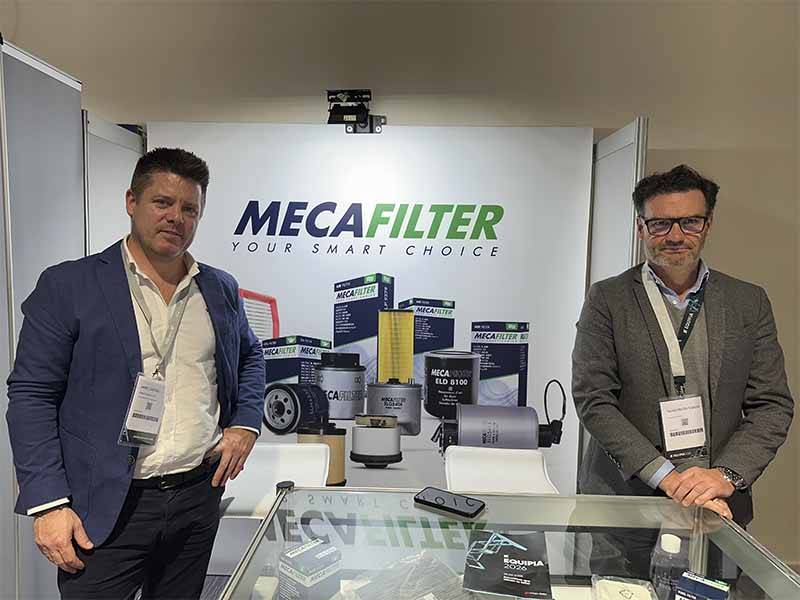 Dos hombres frente a un stand de MECAFILTER con filtros para automóviles y material promocional, reflejando el éxito de asistencia en el evento Balance de Equipia 2026.