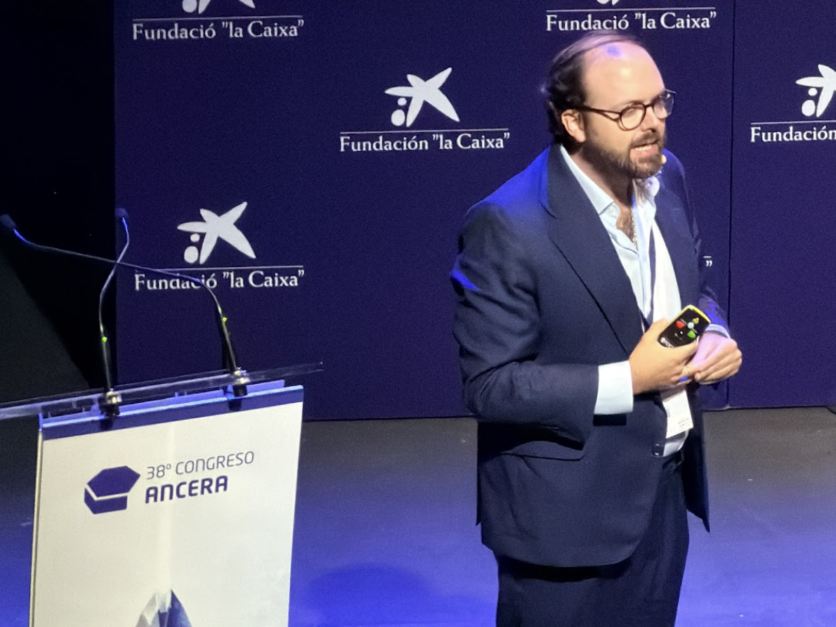 Un hombre trajeado habla en el escenario del 38º Congreso Ancera, con un telón de fondo de la Fundación "la Caixa".