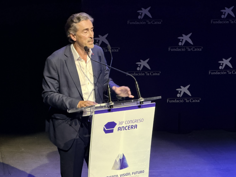 Hombre trajeado hablando en una tribuna durante el 38º Congreso de ANCERA, con logotipos de la Fundación "la Caixa" detrás.
