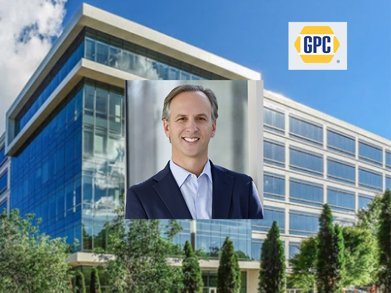 Un hombre vestido con traje sonríe frente a un moderno edificio de oficinas en cuya esquina se ve el logotipo de GPC, lo que simboliza el crecimiento y el éxito que caracterizan al director general de la empresa.