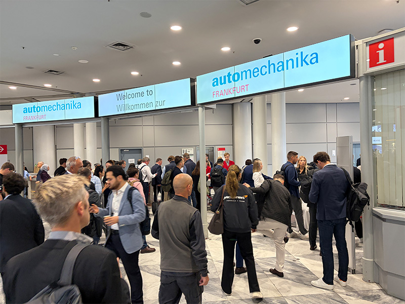 Multitud de personas en la entrada del evento Automechanika Frankfurt, con carteles de bienvenida en lo alto, anticipando la llegada de aún más visitantes para la edición de Automechanika Frankfurt 2026.