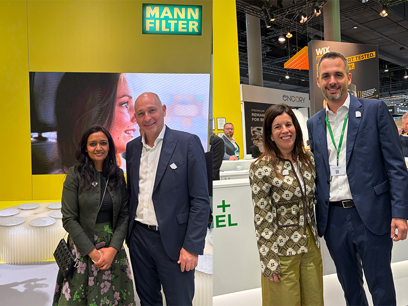 Cuatro personas posando y sonriendo en una feria comercial con los logotipos de MANN-FILTER, MANN+HUMMEL y otras empresas a sus espaldas, mientras presentan las novedades en Automechanika.